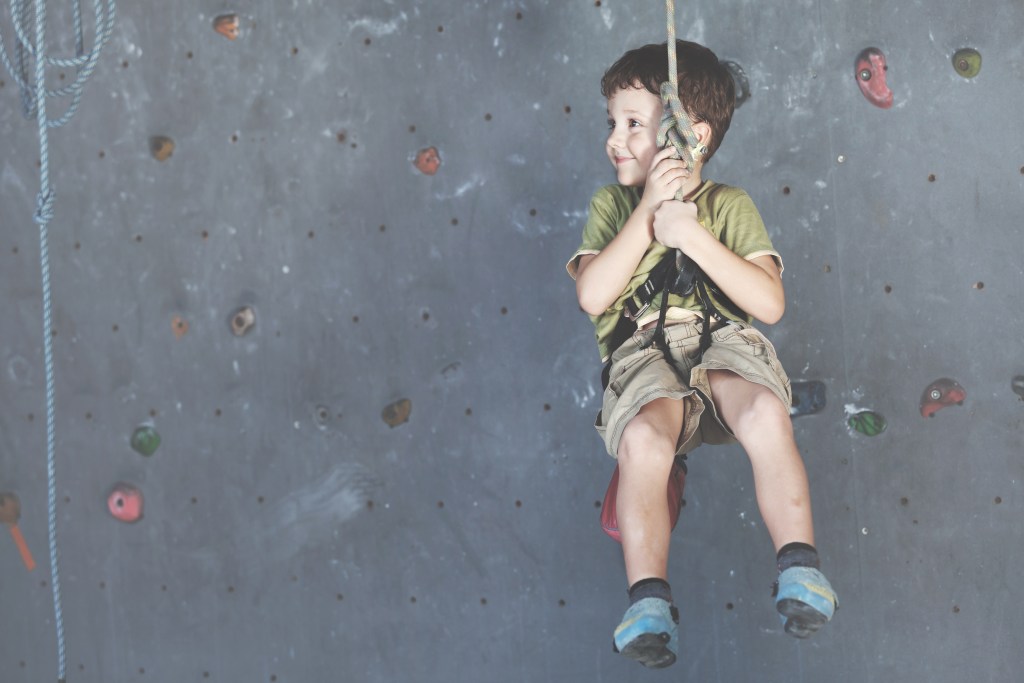 happy student climbing on an indoor wall